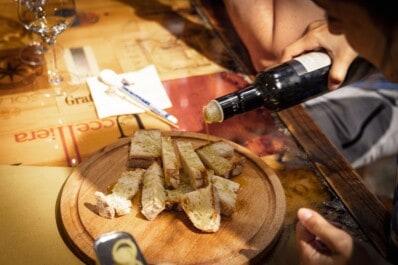Authentic olive oil is poured over bread during a wine tasting in Florence, Italy