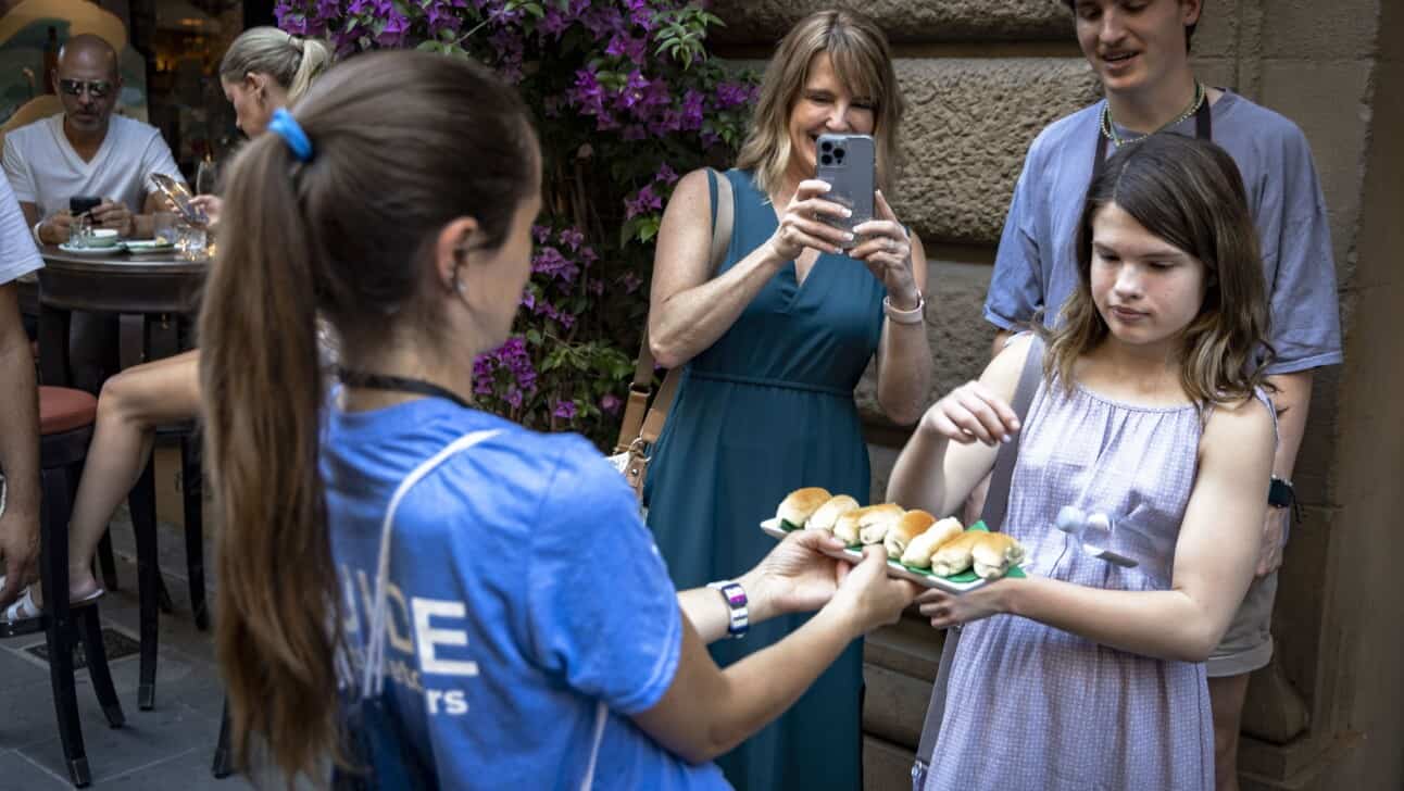 A girl chooses a truffle sandwich while her mom takes a picture