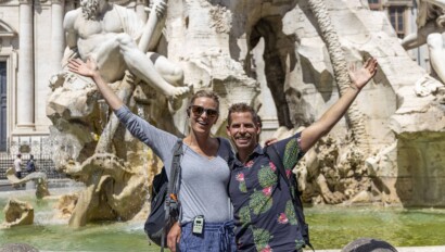 A couple poses for a photo in front of the Navona fountain in Rome, Italy