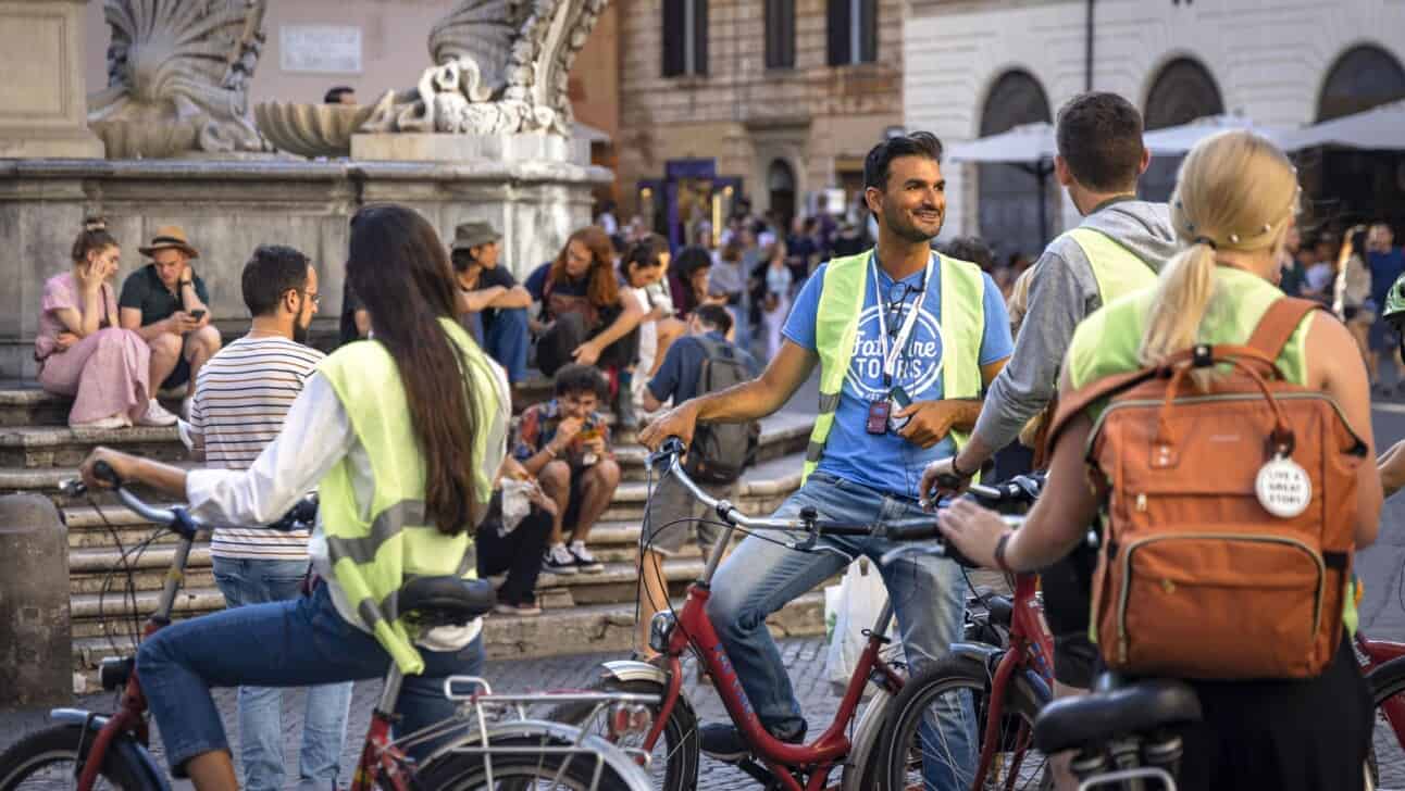 A guide gathers the group around a fountain in Rome, Italy