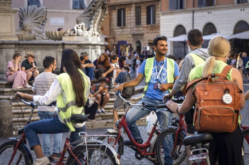 A guide gathers the group around a fountain in Rome, Italy