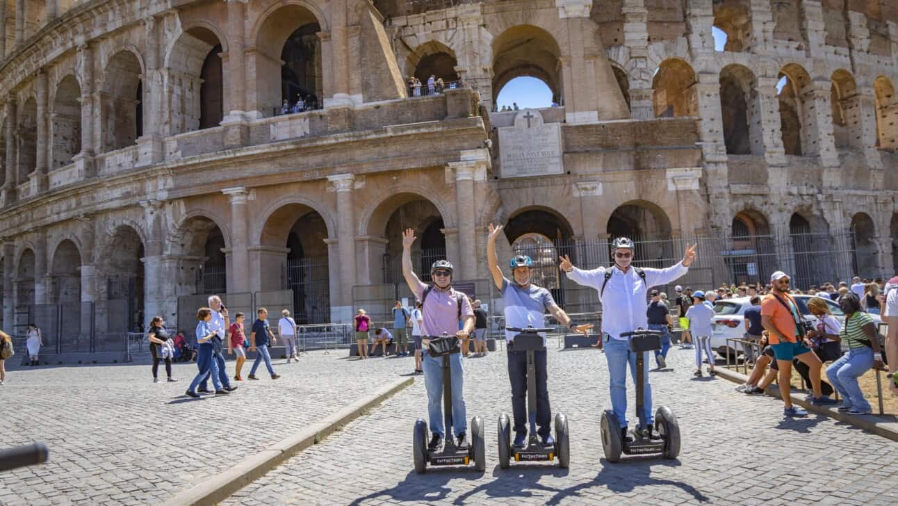 Three men riding Segways in front of the Colosseum in Rome, Italy