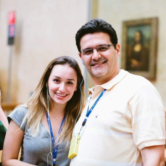 A couple with poses for a photo inside the Louvre Museum