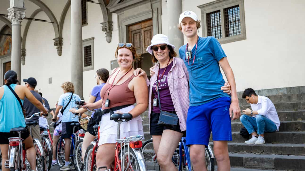 3 friends pose for a photo with a bike in Florence, Italy