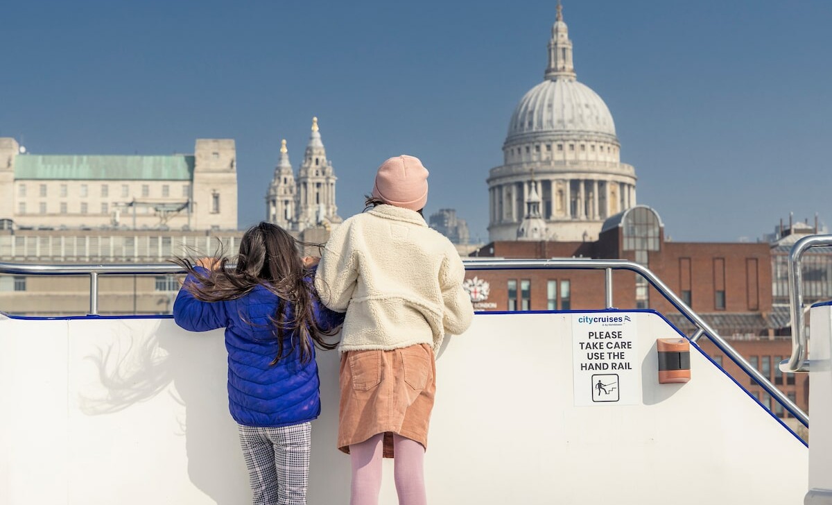 Two young girls look at London from the river with St. Paul's Cathedral in the background.