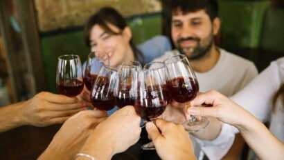 A group cheers with red wine