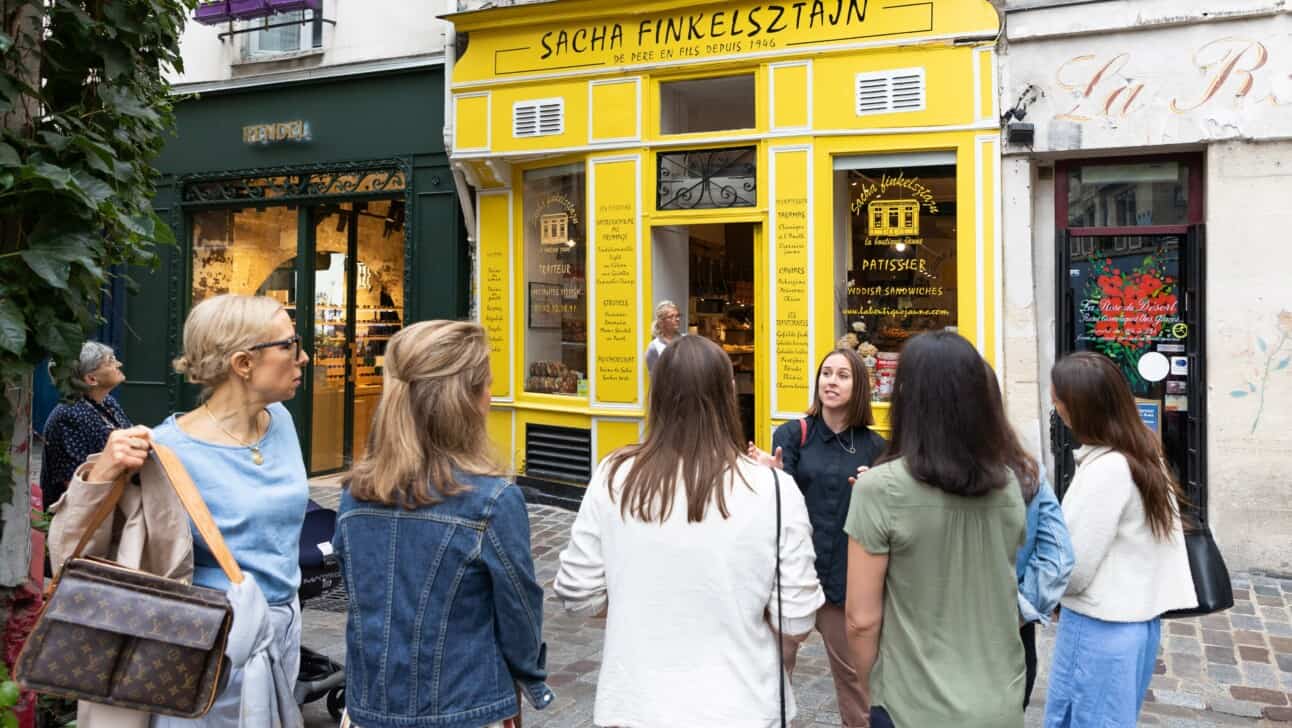 A group on rue de Rosiers learning about the Jewish bakeries in the neighborhood