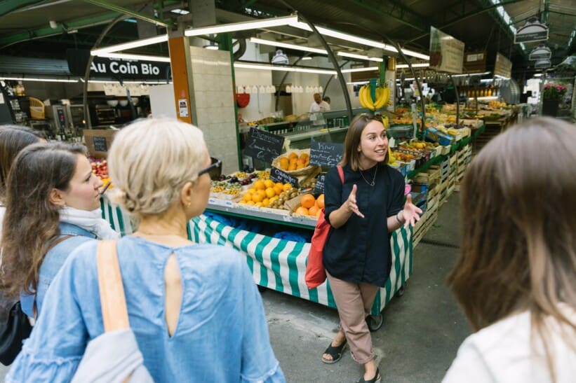 The guide explains the market tradition to the group in Paris, France