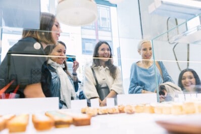 Women look at the selection of pastries in a shop in Paris, France