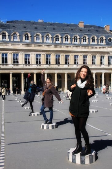 3 women pose on the black and white pedestals in Paris' Palais Royal