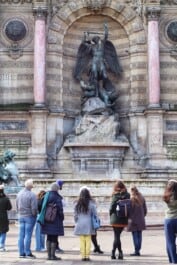 A crowd gathers un front of Place Saint-Michel in Paris, France