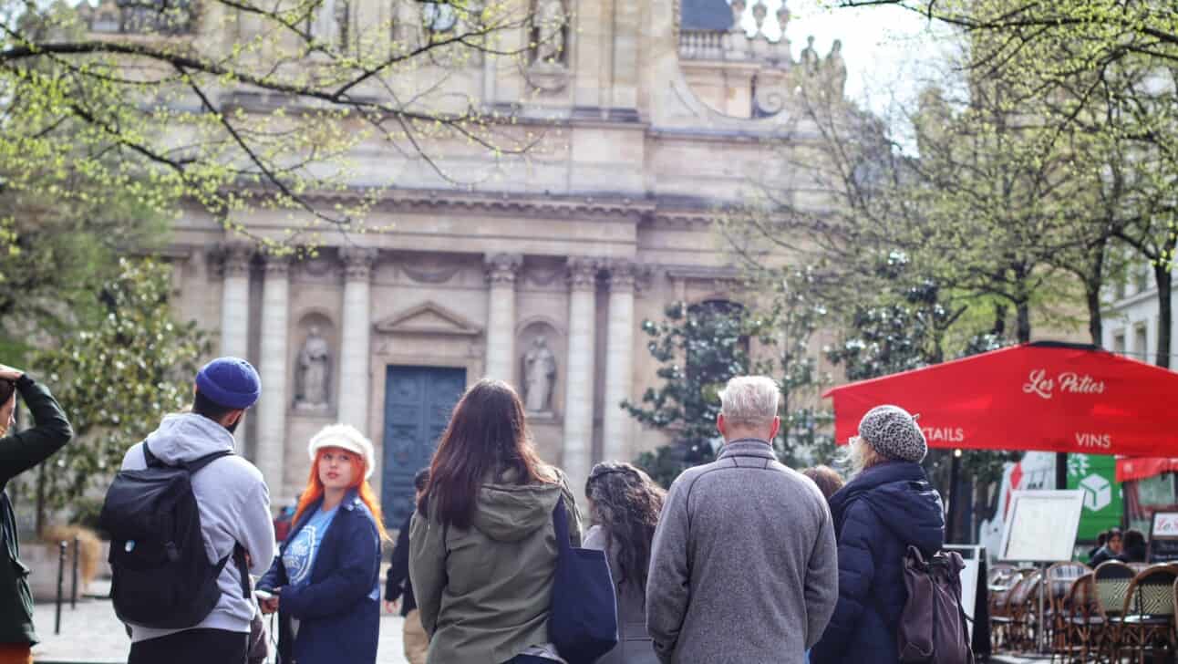 A group of tourists learn about the Sorbonne University in Paris, France