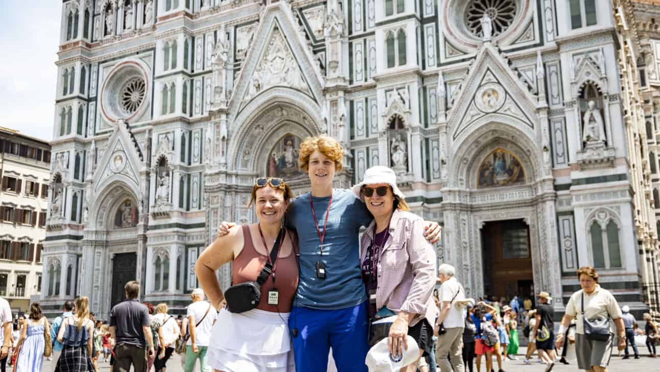 A group of 3 friends pose for a photo in front of the Duomo in Florence, Italy