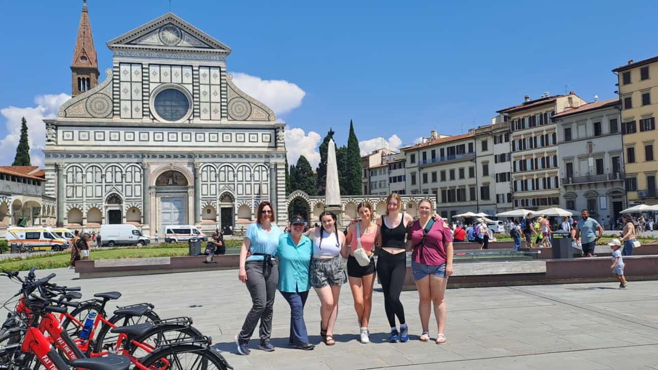 A group of six women pose for a picture in Santa Maria Novella Square in Florence