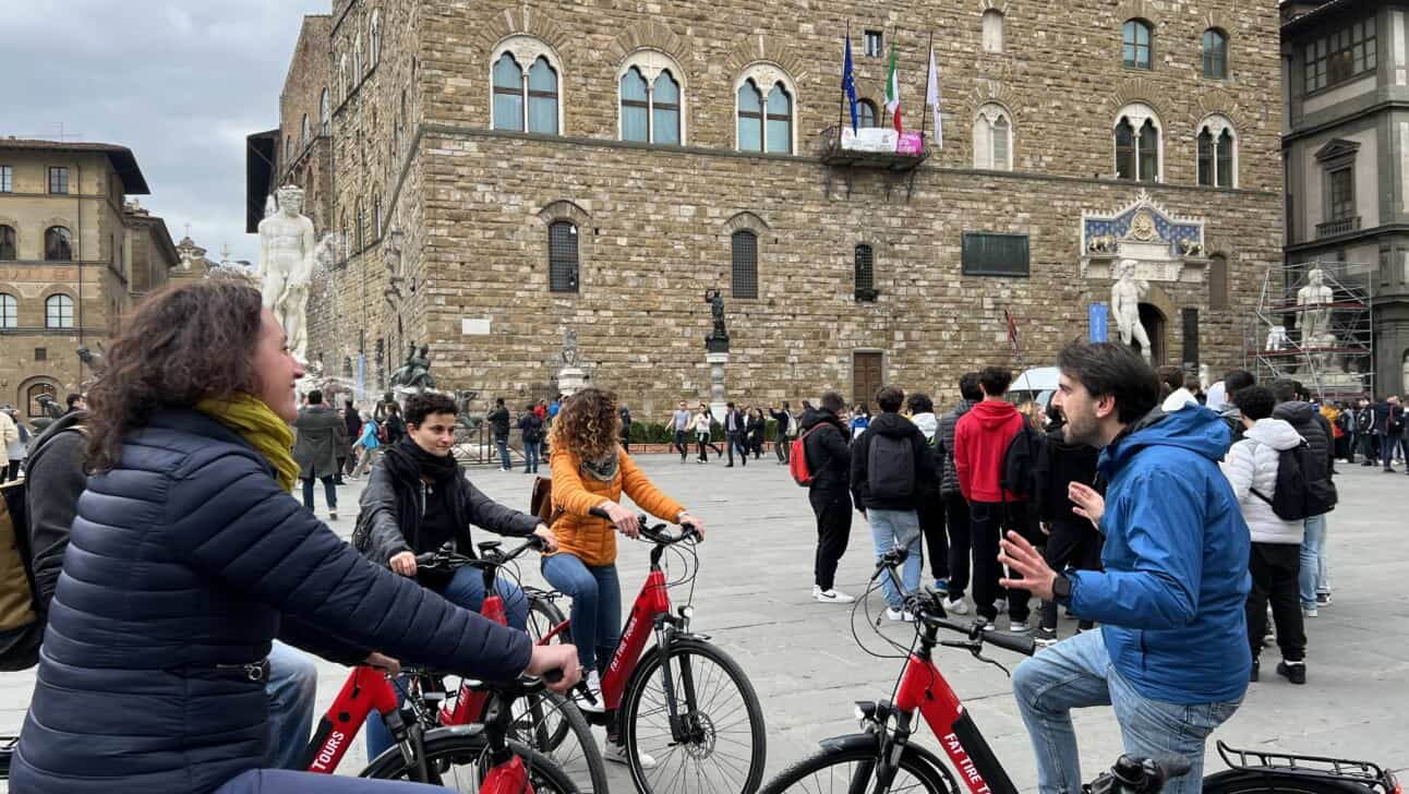 A group of cyclists in the Piazza della Signoria in Florence, Italy