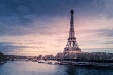 The Eiffel tower in front of a pink and blue sky