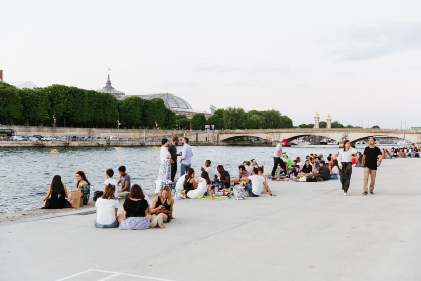 People lounging along the river Seine in Paris, France