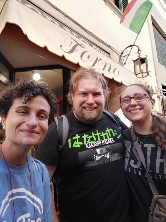 3 people smile for a photo in front of an Italian restaurant.