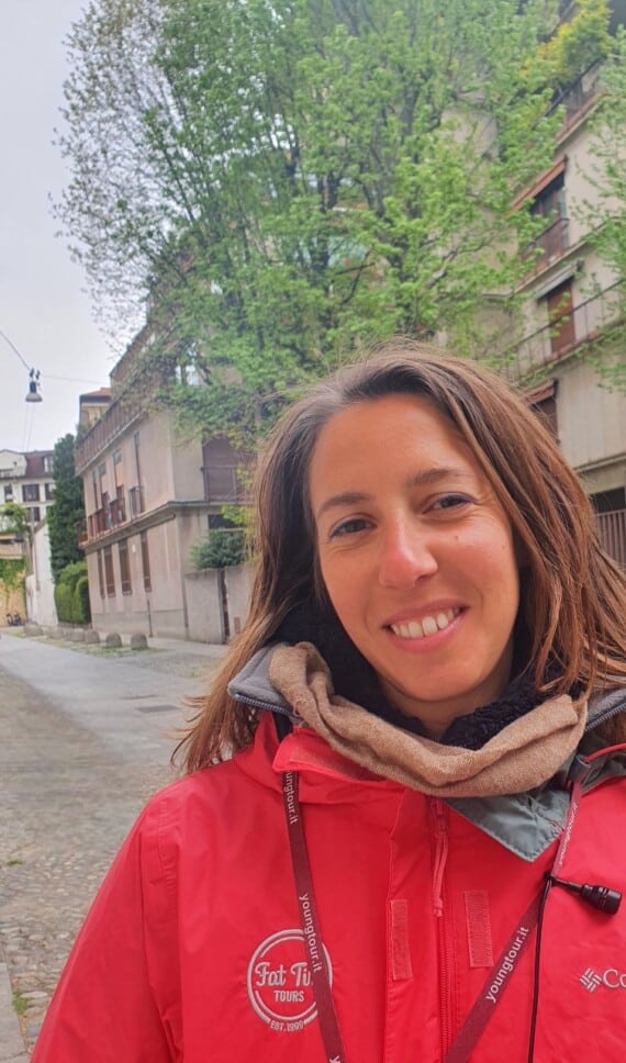 A smiling woman in a red jacket.