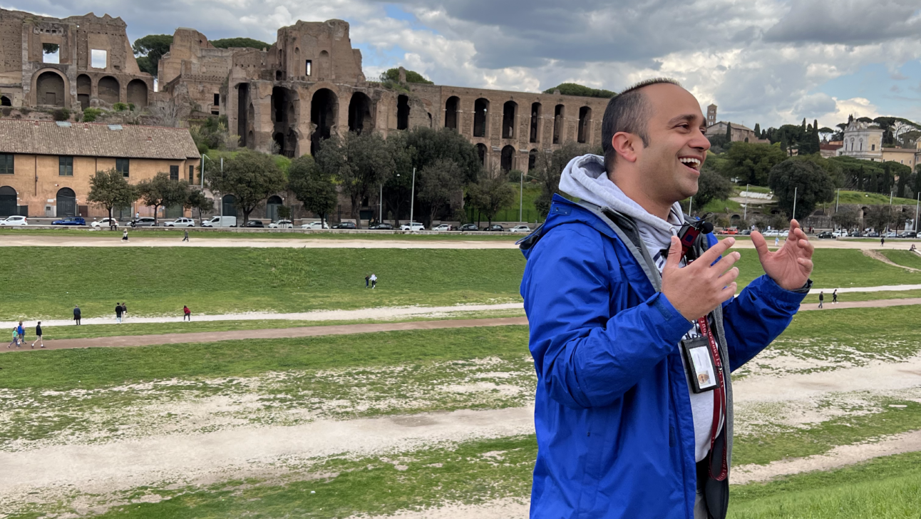 A guide in a blue coat explains Circus Maximus in Rome, Italy