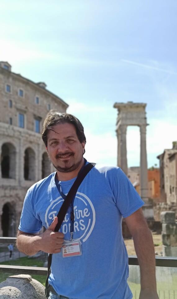 A tour guide in a blue t-shirt gives a thumbs up