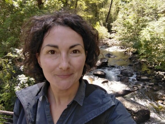 A woman taking a selfie in front of a creek