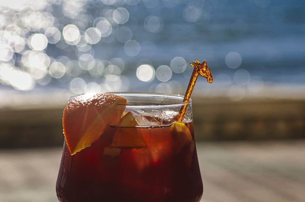 A glass of sangria with an orange slice on the rim