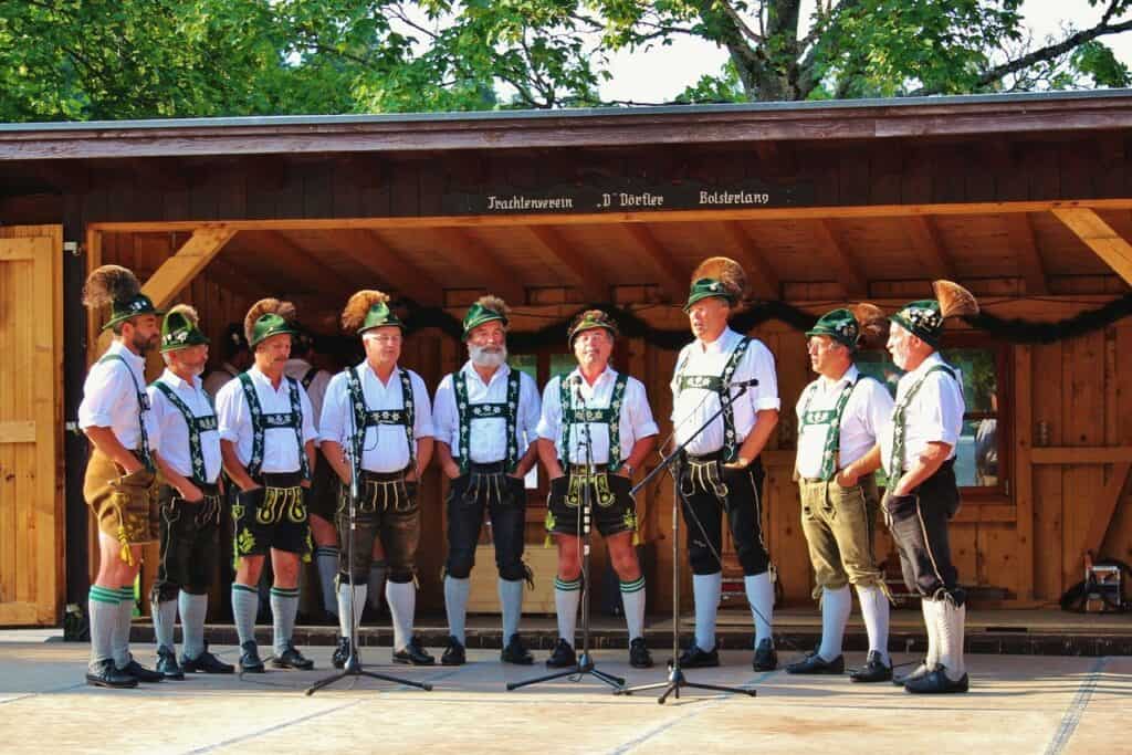 A group of men wearing traditional lederhosen with green hats