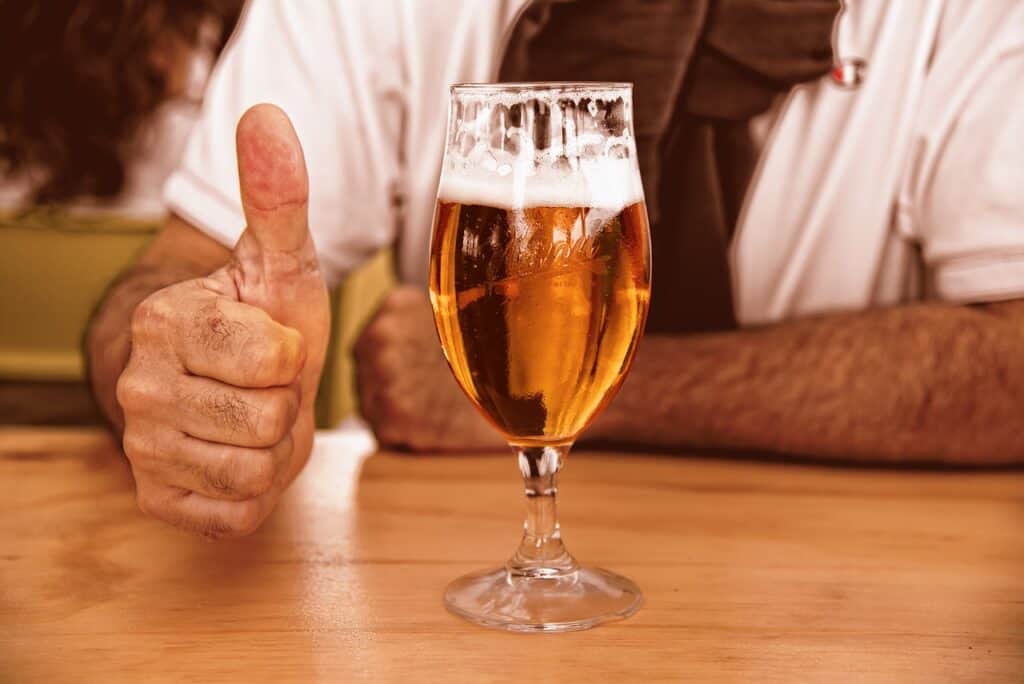 A man gives us a thumbs up next to a pint of beer