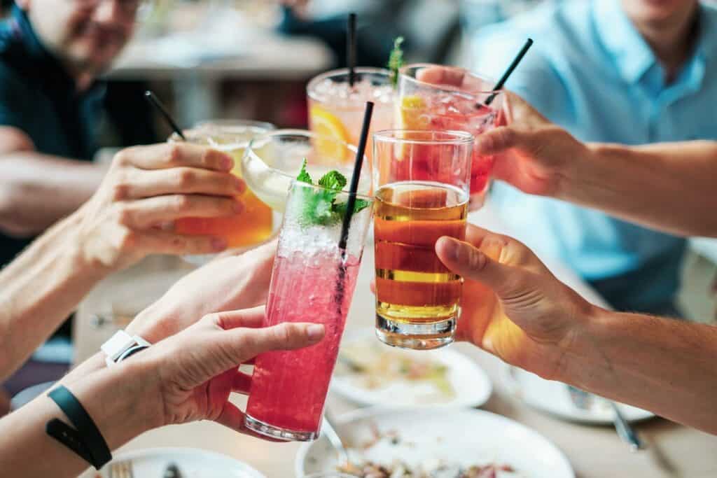 A group of people raise glasses of different drinks in celebration 
