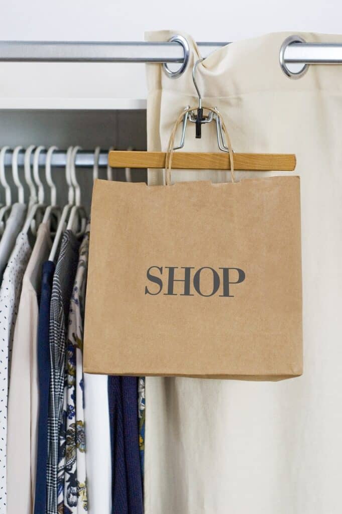 A brown shopping bag with the word "Shop" hangs in a store