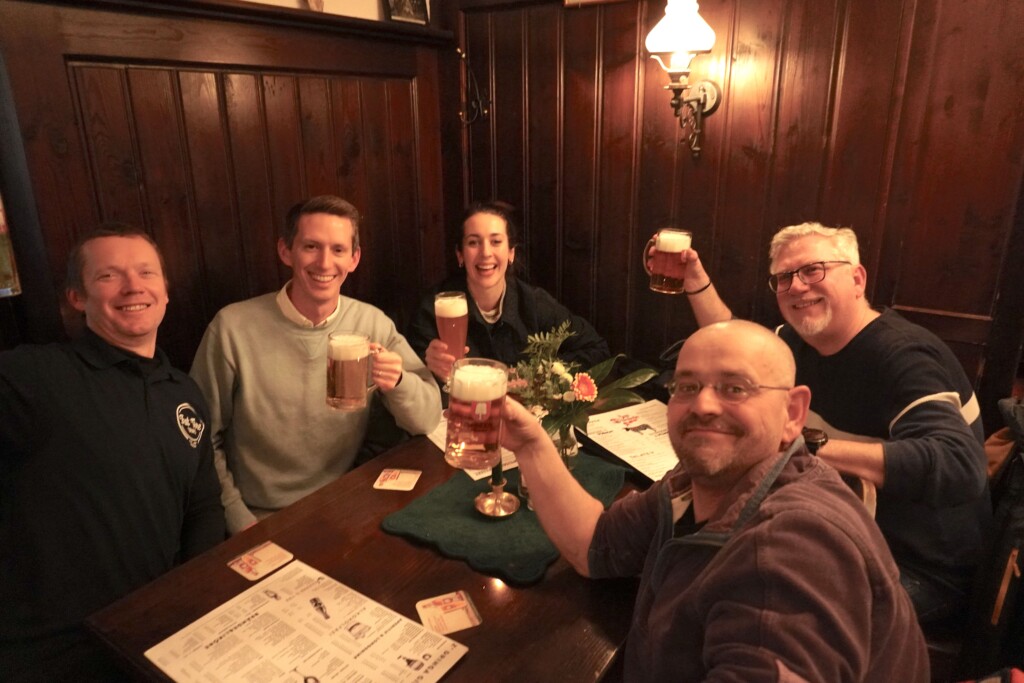 A group of five hold up their drinks at a beer hall in Munich