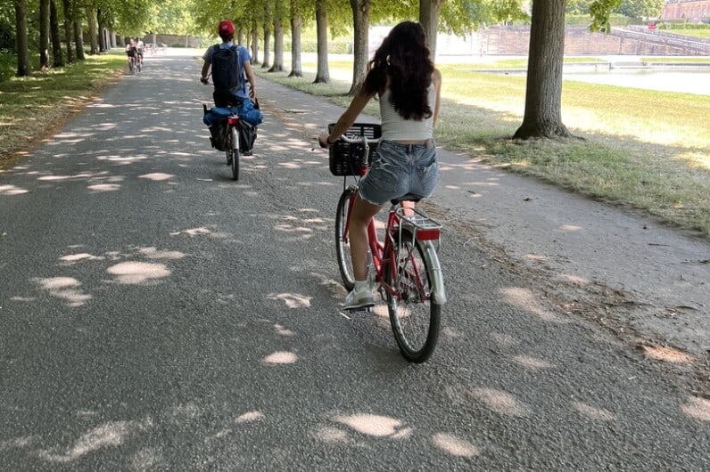 Two people riding bikes through Versailles