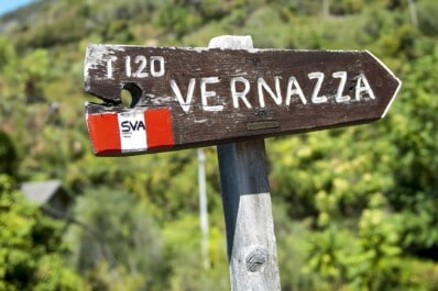 A wooden sign post showing the direction to Vernazza