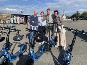 A family of four on e-scooters pose for a photo at Piazzale Michelangelo