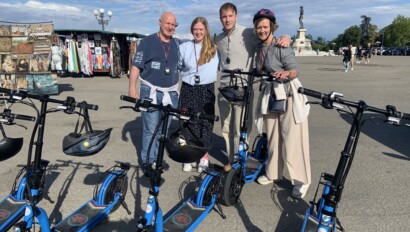 A family of four on e-scooters pose for a photo at Piazzale Michelangelo