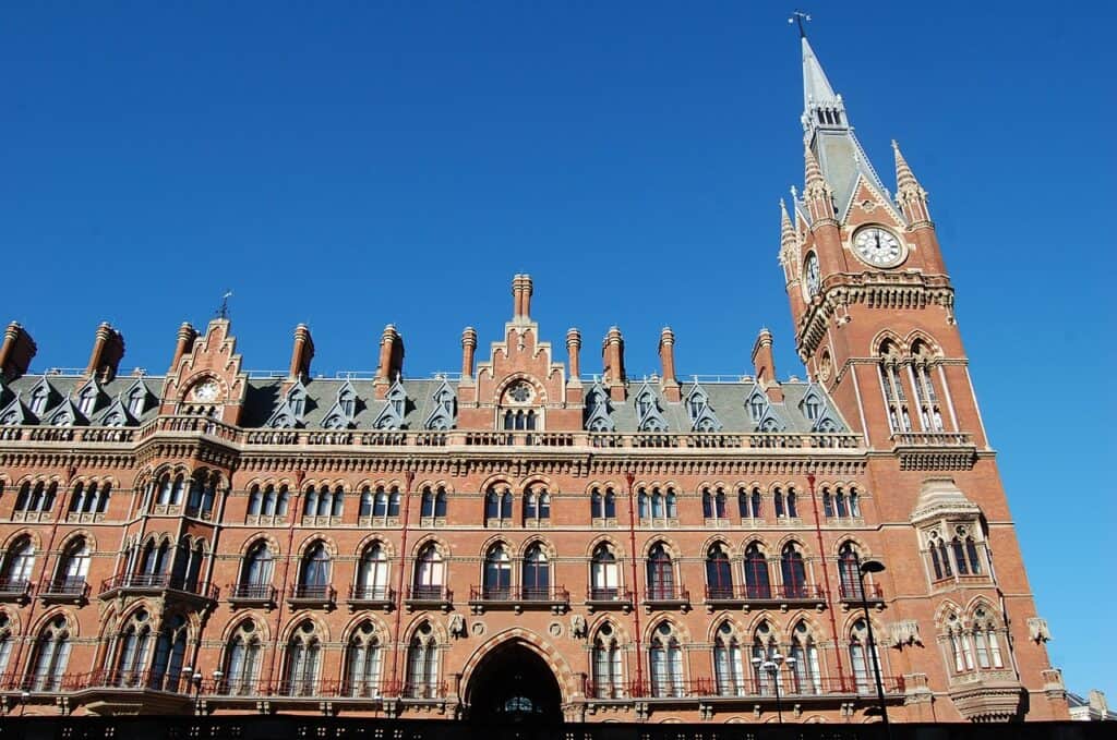 Exterior view of London's King Cross station on a bright sunny day with a blue sky