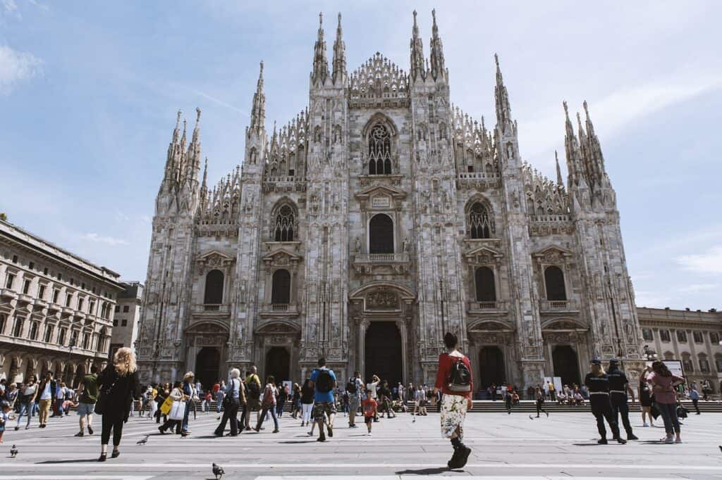 A Milan cathedral is pictured in daylight as visitors walk in front of the church