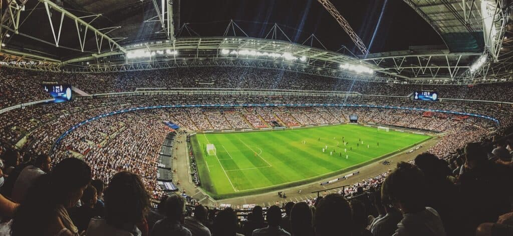 A soccer stadium full of people at nighttime 