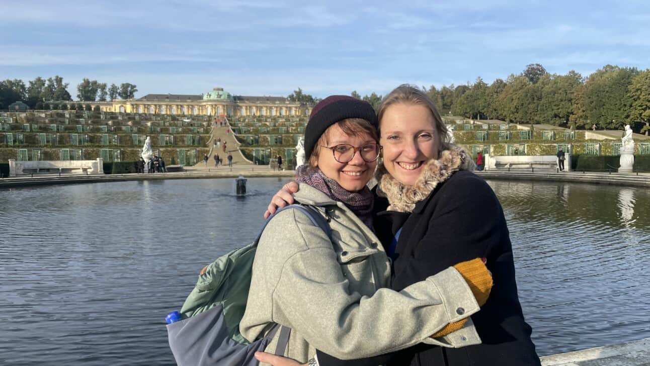 Two women smiling in front of Sanssouci Palace in Potsdam