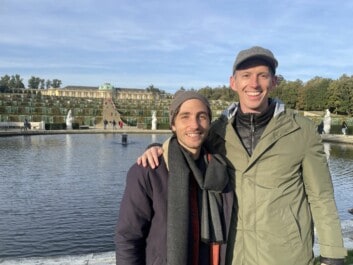 Two men smiling in front of Sanssouci Palace in Potsdam