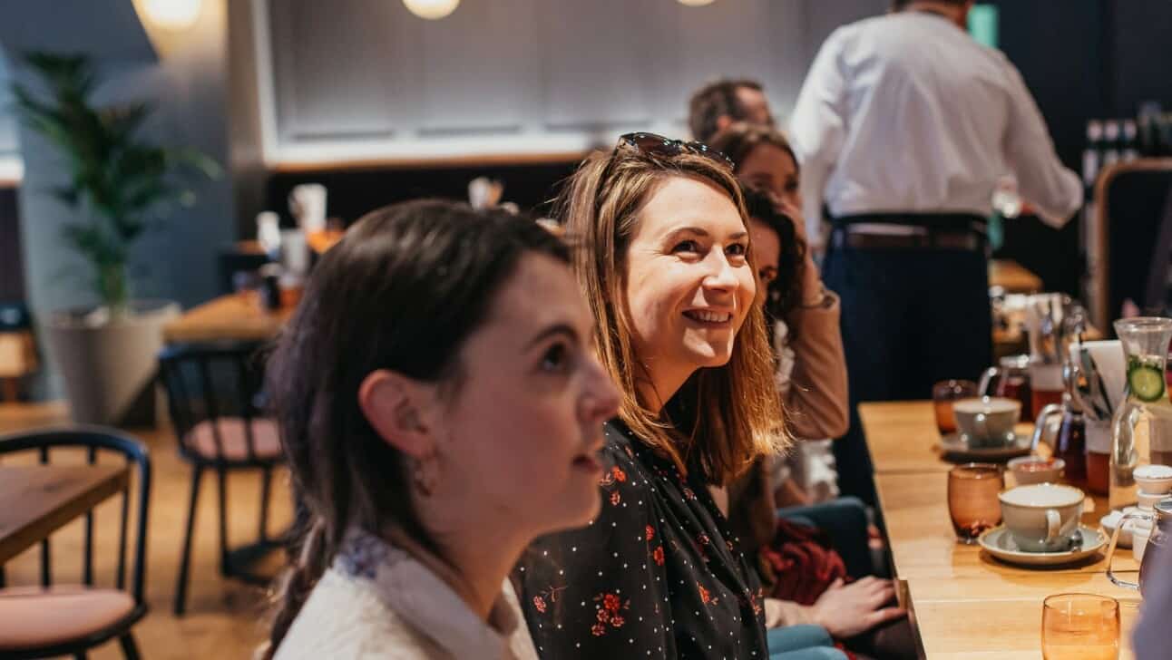 Women listen to their tour guide at a food tasting