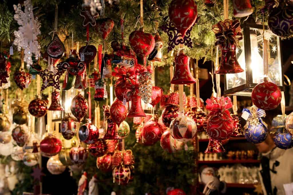 Red holiday ornaments hang from garland