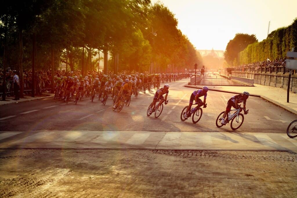 Cyclists racing through the streets of Paris with trees in the background