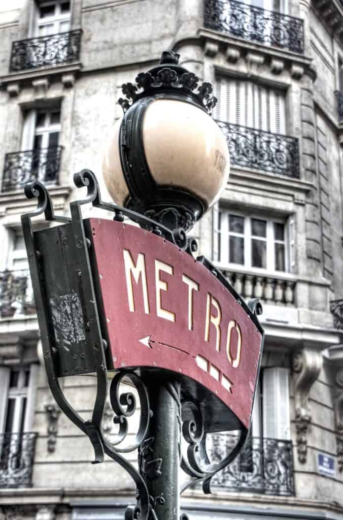 A Paris metro sign with white lettering and a red background