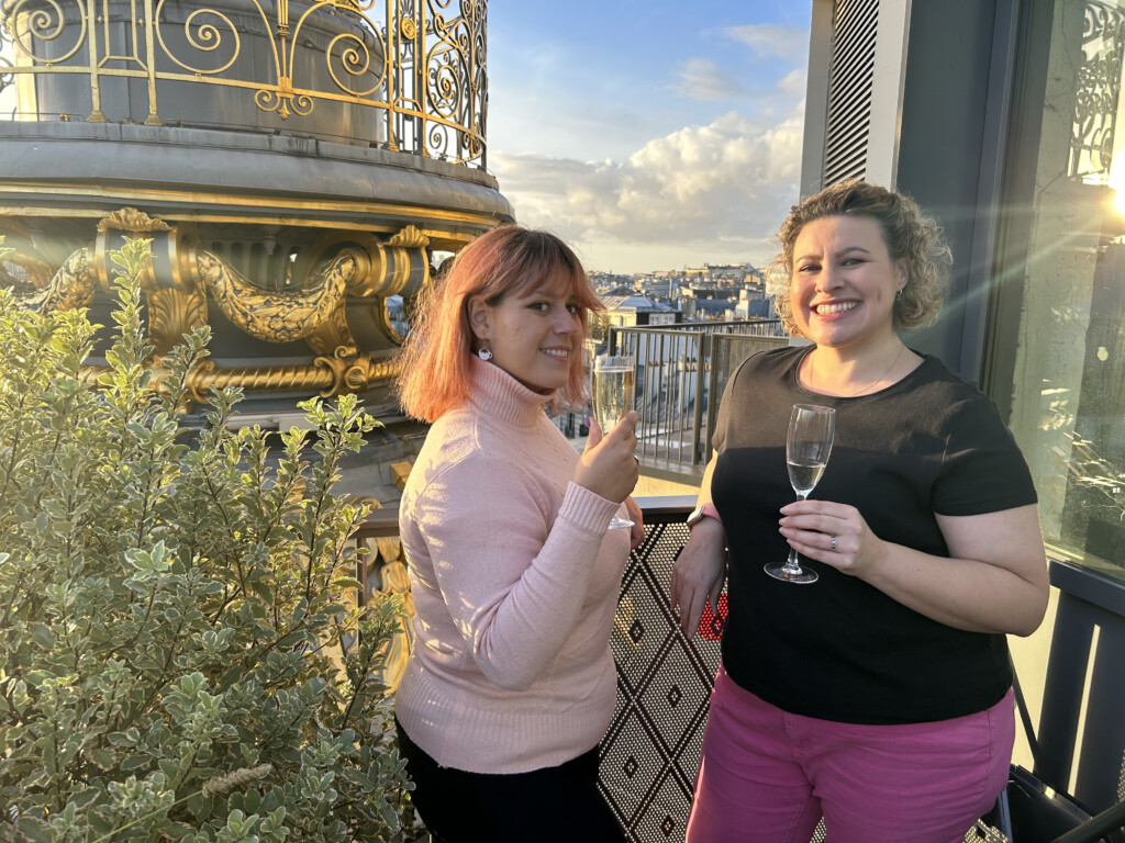 Two women cheers their champagne atop Printemps in Paris