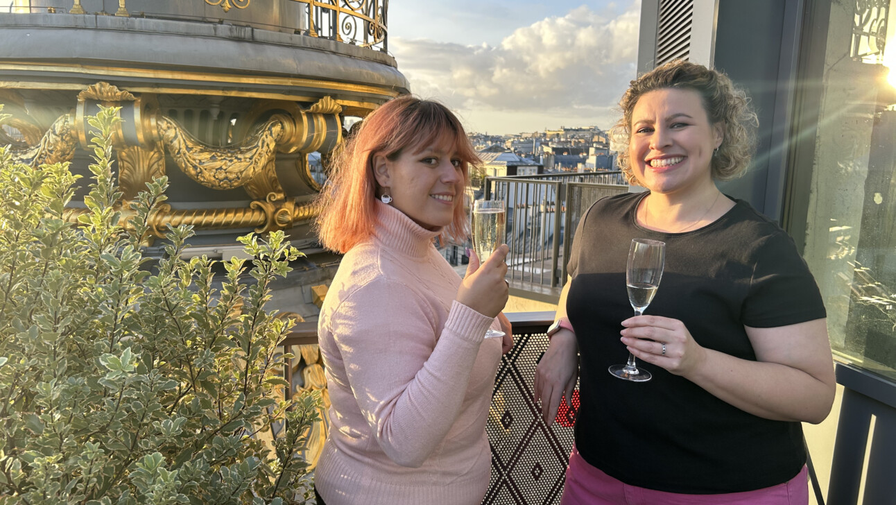 Two women cheers their champagne atop Printemps in Paris