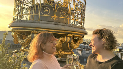 Two women cheers their champagne atop Printemps in Paris