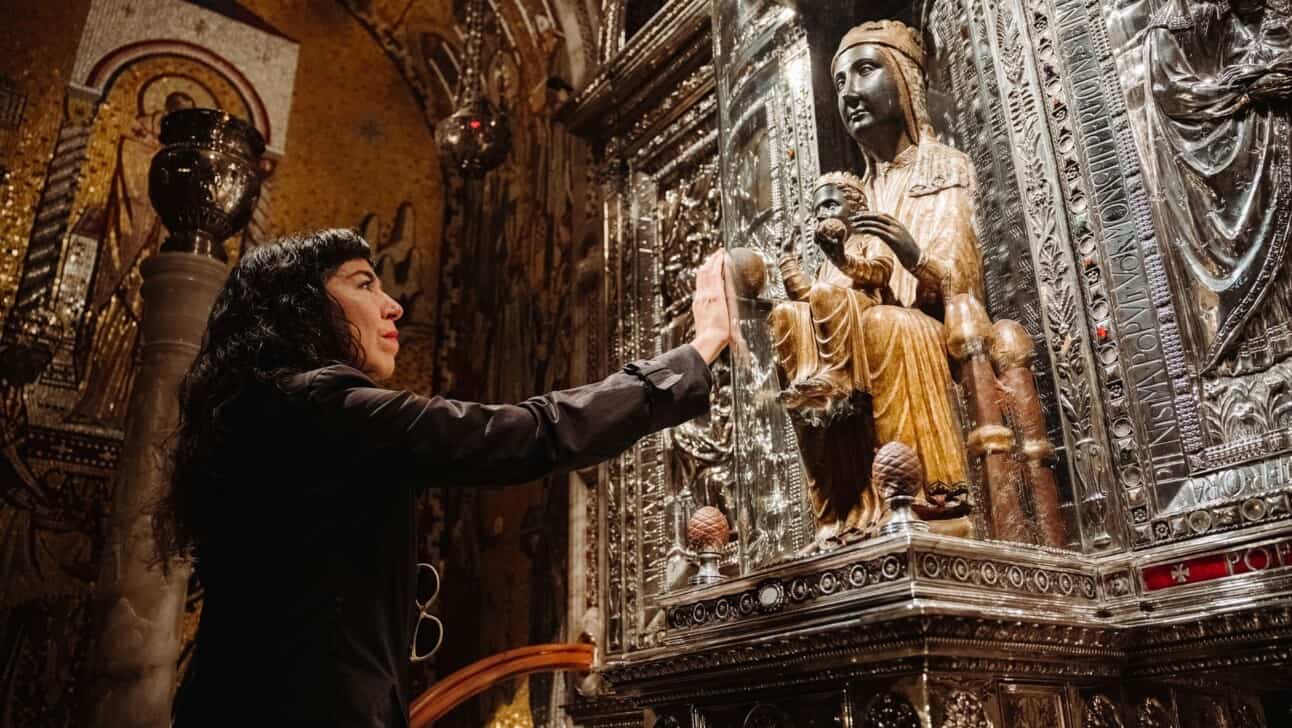 A woman touches the Black Madonna statue in the Montserrat Monastery outside Barcelona