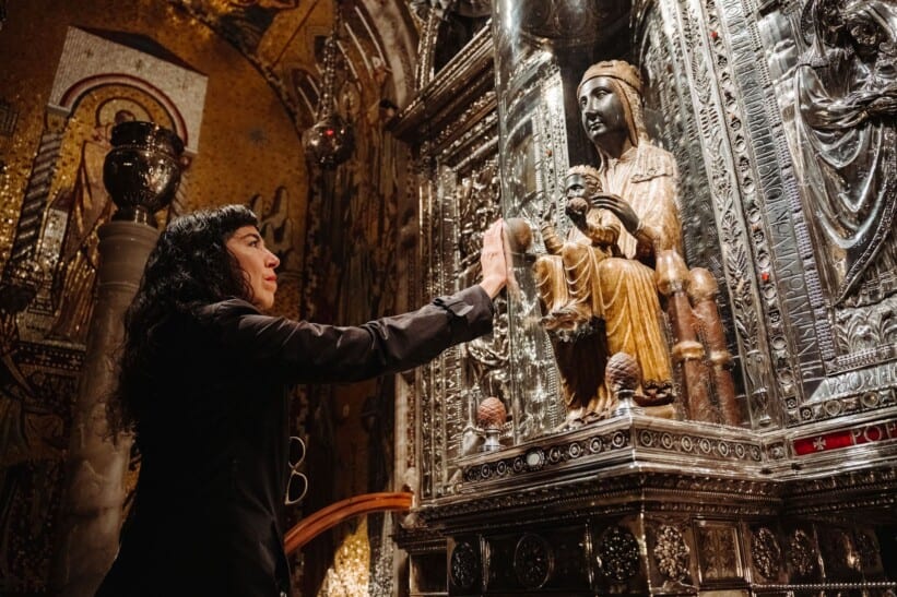 A woman touches the Black Madonna statue in the Montserrat Monastery outside Barcelona
